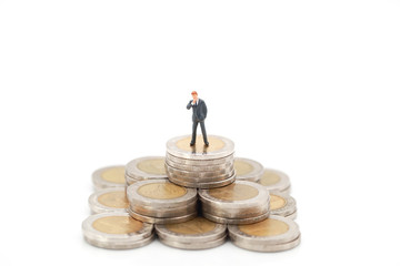 Miniature people: businessman standing on stacking coins , Financial and Business competition concept using as background