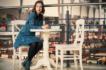 Fototapeta na wymiar portrait of a young dreamy woman sitting in the cafe