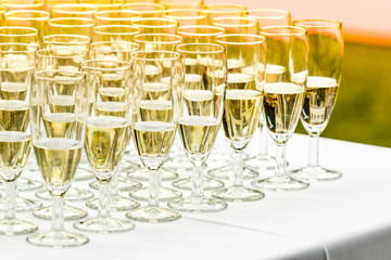 Many glasses of champagne on white table