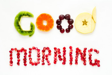 Good morning concept. 'Good morning' words laid out with pieces of fruit and pomegranate seeds. Lovely message. Flat lay. Top view. Space for copy
