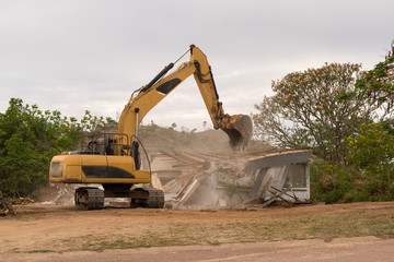 Fototapeta na wymiar Bulldozer demolishing house
