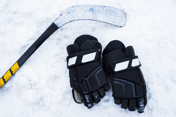 Fototapeta premium The gloves and hockey stick lay on the snow