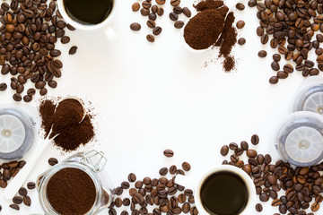 Background with assorted coffee: cups of espresso, coffee beans, powder and capsules on white baclground. Space for copy. Top view. Flat lay