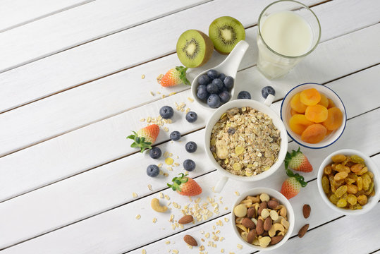 Healthy food, healthy muesli breakfast with milk and fruits on white wooden table