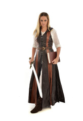 full length portrait of girl wearing brown  fantasy costume, holding a sword. standing pose on white studio background. 