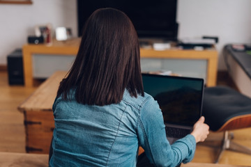 Woman sitting on a sofa using a laptop