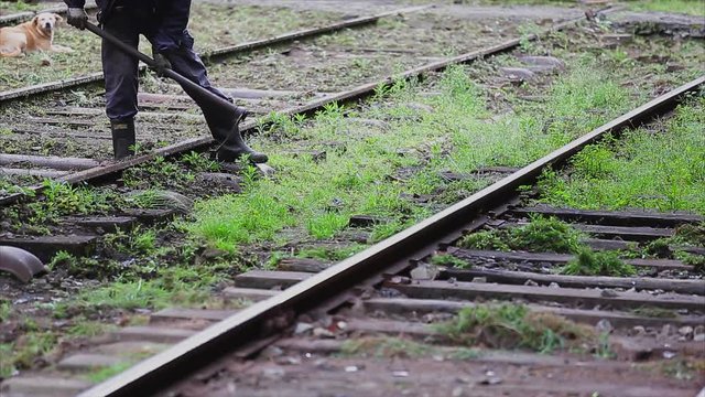 Man works at railway with mattock