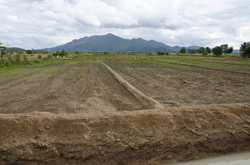 Field preparation area with sky and mountains.