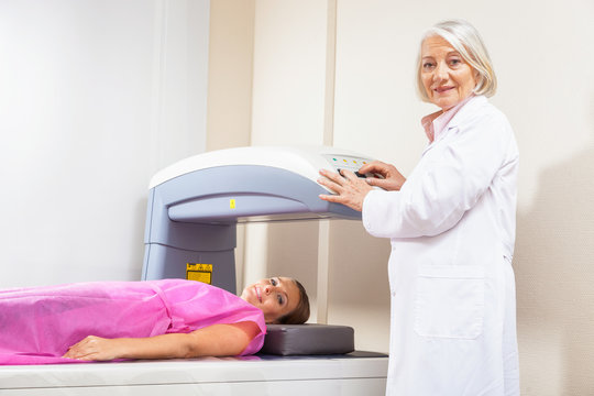 Woman in 40s undergoing medical x-ray with elderly doctor