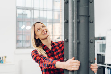 Fototapeta premium Pretty woman hanging onto a metal pillar