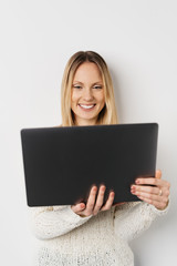 Blonde smiling woman using laptop