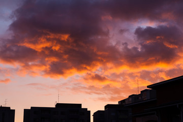 Vibrant sunset clouds sky and building rooftops