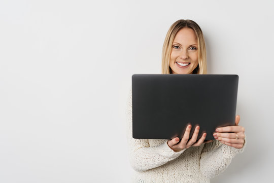 Portrait of blonde smiling woman using laptop