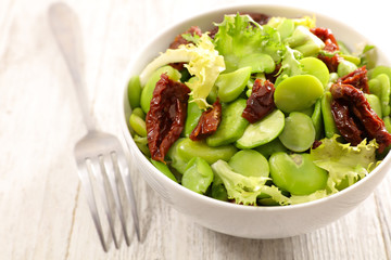 broad bean salad on wood background