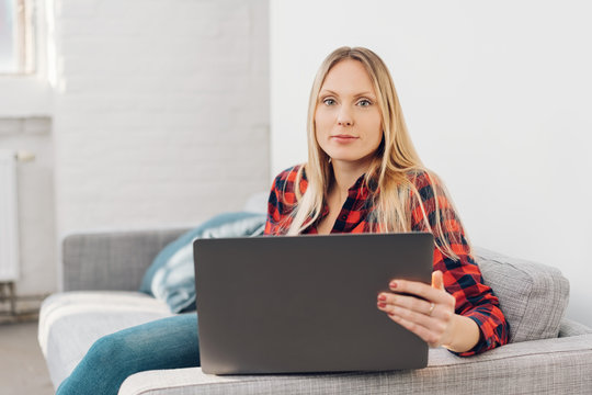 Attractive blond woman using a laptop at home