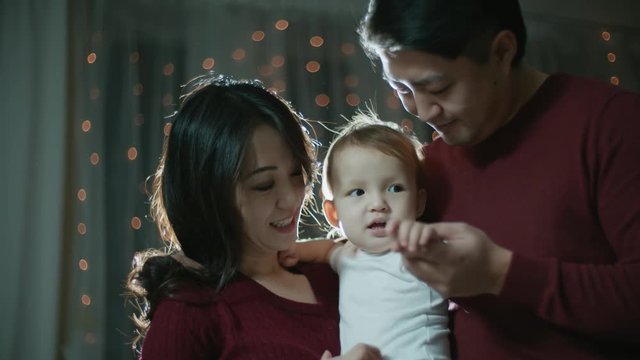 Asian couple with a little baby on their hands, happy family moments, slow motion