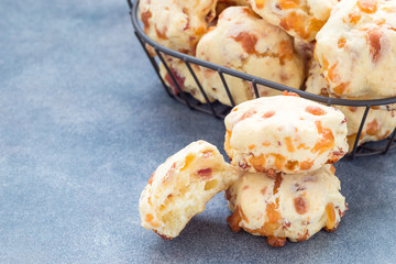 Homemade savory cookies with cheese and bacon in basket and on the table, horizontal, copy space