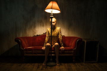 Teeanage girl sitting on old velvet couch