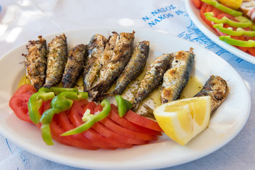 Seafood, grilled sardines served with vegetables in traditional Greek tavern. Naxos island. Greece.