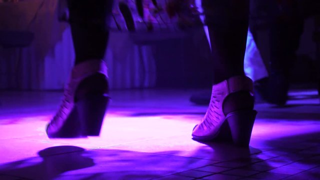 Night club or restaurant. The feet of people who dance on the dance floor.