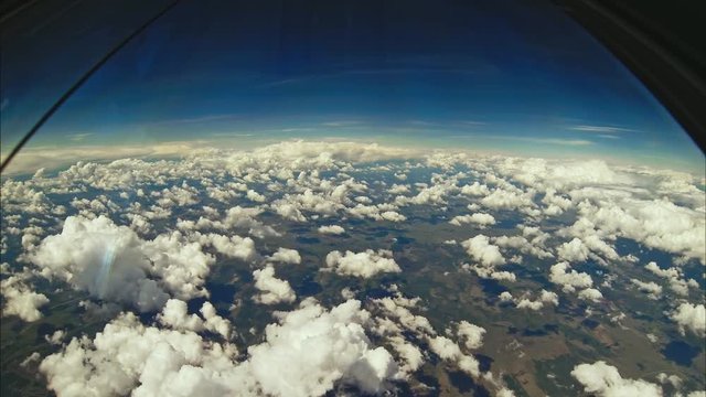 AERIAL view from COCKPIT flying above CLOUDS &mdash; clear sky, horizon line and layers of atmosphere seen from pilot&rsquo;s perspective
