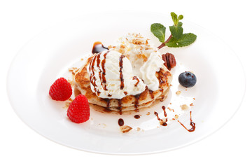 Serving pancakes with ice cream and whipped cream on the plate. Decorated with chocolate syrup,...