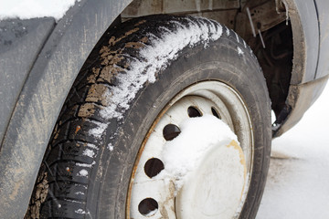 Fototapeta na wymiar Front wheel of the truck covered with snow closeup
