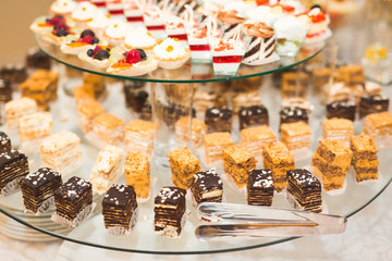 Delicious and tasty dessert table with cupcakes shots at reception closeup