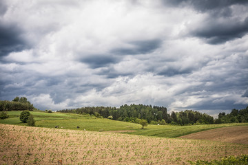 Fototapeta na wymiar Stormy cloudscape over fields and pasture