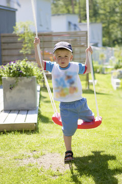 Boy on swing in garden