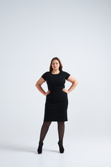 Beautiful girl in fashionable dress posing at studio