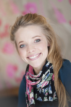 Portrait of young blonde woman with floral scarf smiling