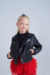 Smiling blonde girl wearing leather jacket posing isolated