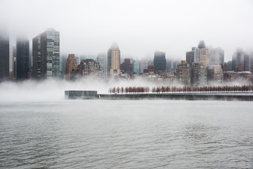 A dense fog covered New York City during the winter's day on January of 2018. View of Manhattan and Roosevelt Island.