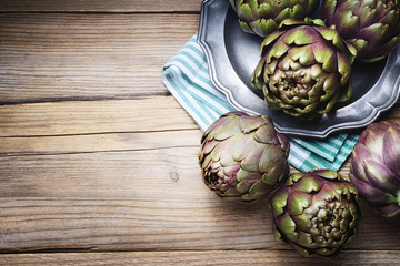 Artichokes on wooden background. Top view, space for text