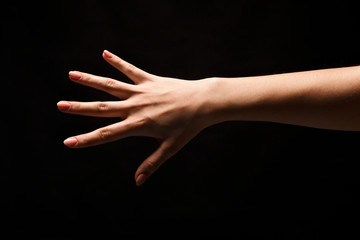 Female hand shows number five isolated at black