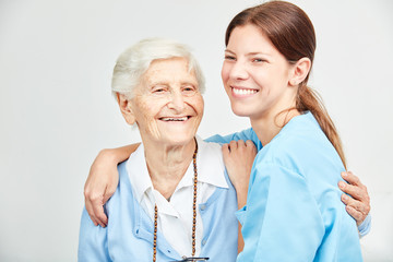 Pflegehilfe und glückliche Seniorin umarmen sich