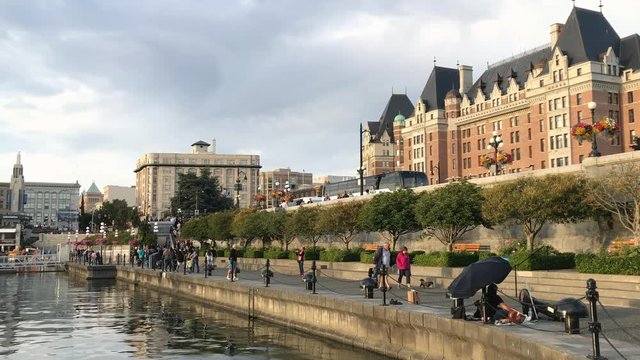 VICTORIA, CANADA - AUGUST 2017: Tourists relax along city port at night. Victoria is a famous destination in Canada