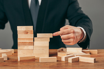 Man and wooden cubes on table. Management concept