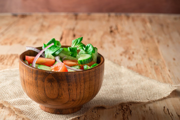 Fresh salad in wooden bowl on rustic salad.