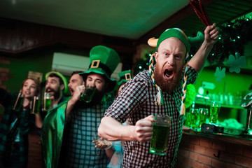 The man in the Viking hats is holding the sausages like a sword.