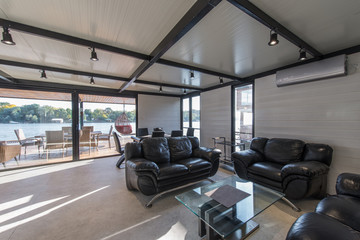 Fototapeta premium Leather sofas in luxury cottage by river