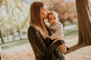 Fototapeta premium Young mother and baby boy in autumn park