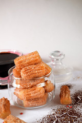 Spanish cookies Churros in a glass jar and chocolate sauce