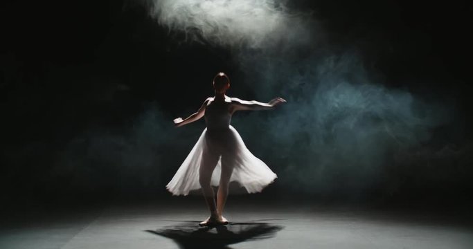 4K video footage beautiful elements of classic ballet ballerina dancing on black background, slow motion