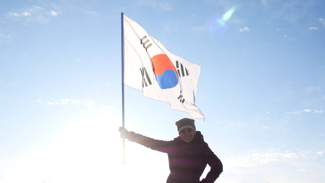 Girl cheerleader with South Korean flag rejoices and supports athletes