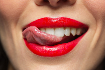 close up of woman with red lipstick licking lips