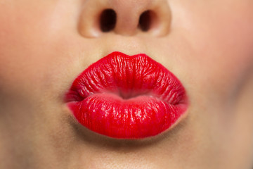 woman lips with red lipstick making kiss 