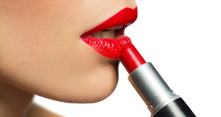 close up of woman applying red lipstick to lips