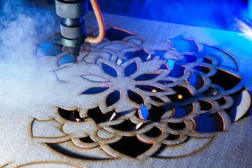The laser cuts out a tree in the form of a mandala 